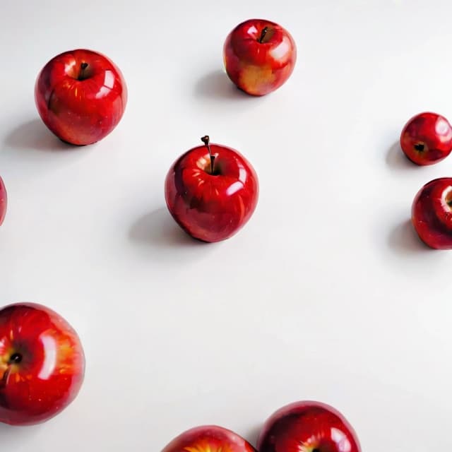 a red apple on a white table