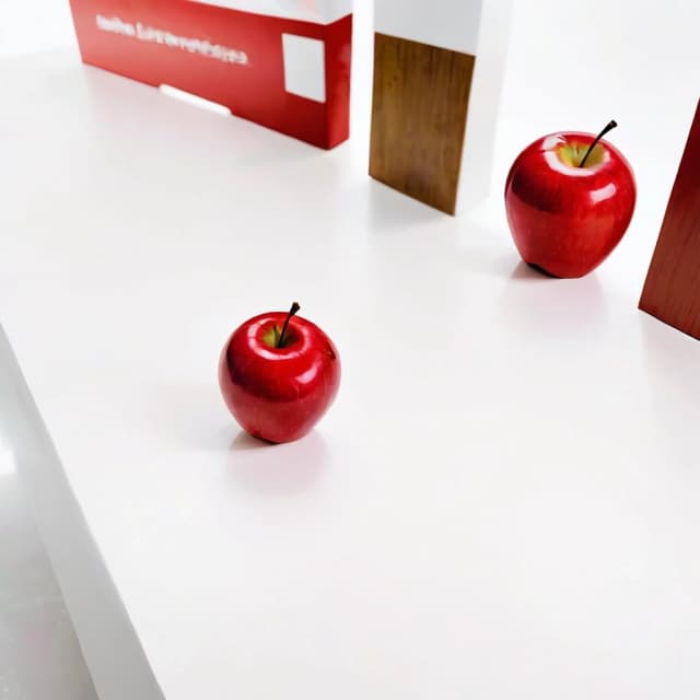 a red apple on a white table