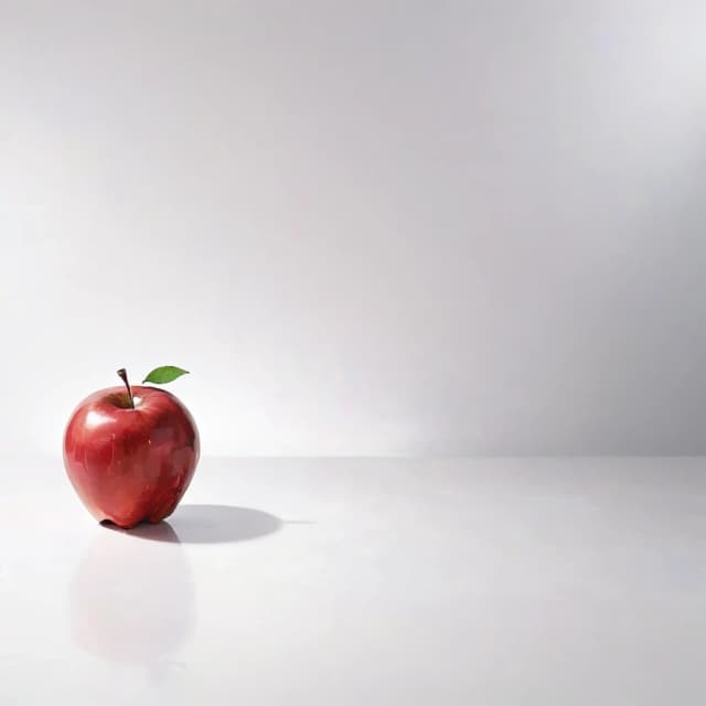 a red apple on a white table