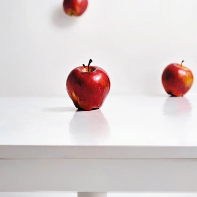 a red apple on a white table