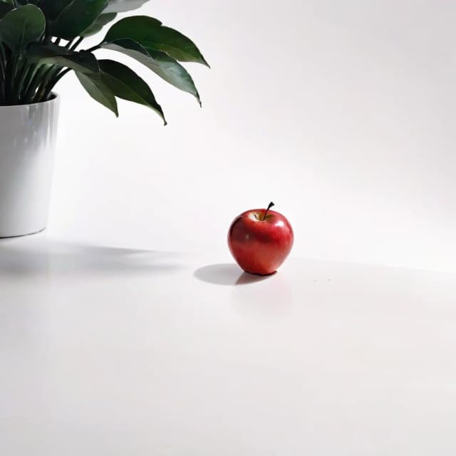 a red apple on a white table