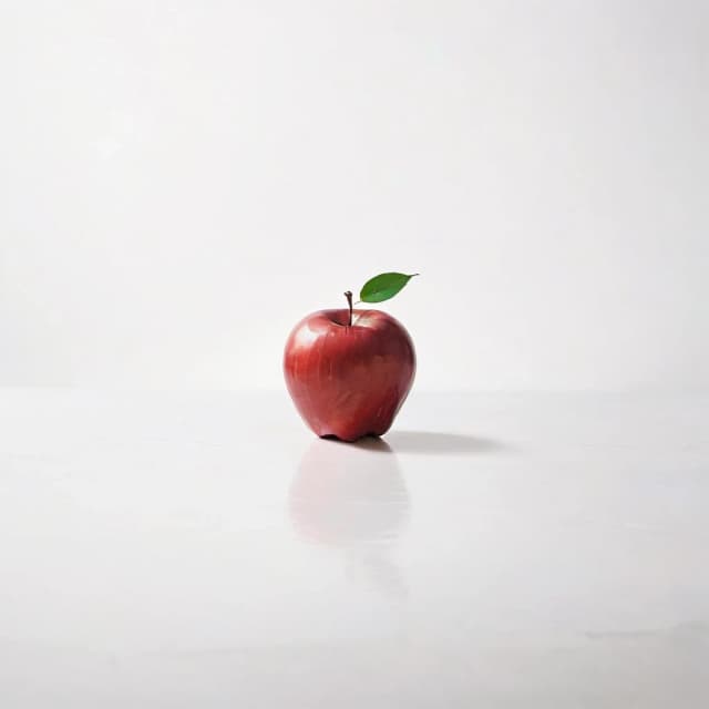 a red apple on a white table