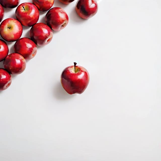 a red apple on a white table