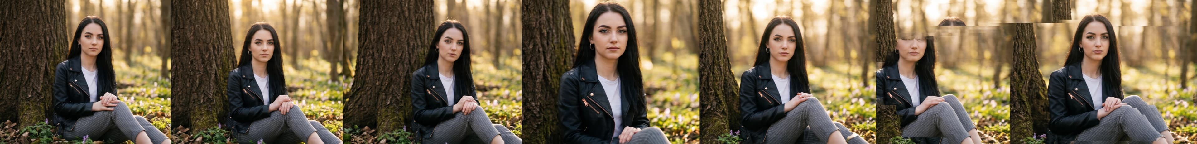 This image captures a young woman with dark hair and striking blue eyes sitting serenely against a tree trunk in a sun-dappled forest, surrounded by early spring foliage.

In detail, the picture features a young woman with long, dark, straight hair flowing over her shoulders. She has prominent blue eyes, enhanced by dark eyeliner, and well-groomed eyebrows. She wears small, silver hoop earrings. Her attire consists of a stylish black leather-look jacket with several rose gold zippers on the front and pockets, worn over a simple white t-shirt. She is also wearing grey trousers with subtle pinstripes. She is seated on the ground, leaning her back against the rough, dark brown bark of a large tree trunk that dominates the left side of the frame. Her hands are gently clasped together in her lap, and her legs are bent. The ground around her is covered with a mixture of dried brown leaves and patches of vibrant green plants, among which small, delicate purple flowers are visible, hinting at the beginning of spring. The background is a soft blur of golden light, creating a beautiful bokeh effect from the sun shining through the trees, suggesting a late afternoon or early morning setting. There are no animals present in the picture. The atmosphere is tranquil and peaceful, imbued with a warm, natural light that evokes a sense of calm and gentle beauty. The woman's direct gaze and composed posture contribute to a serene and somewhat introspective mood.