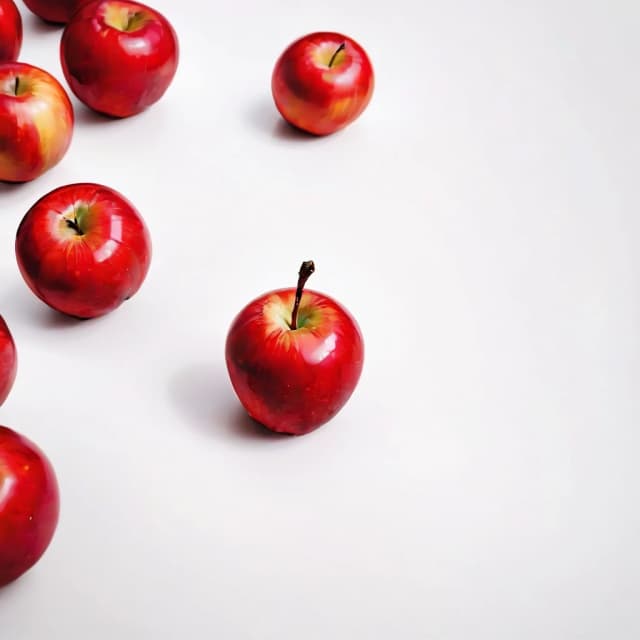 a red apple on a white table