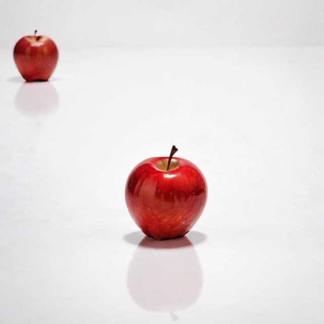 a red apple on a white table