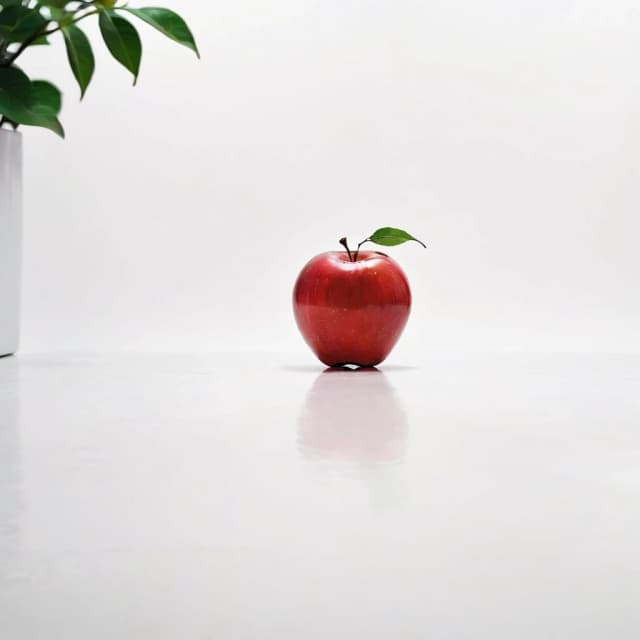 a red apple on a white table