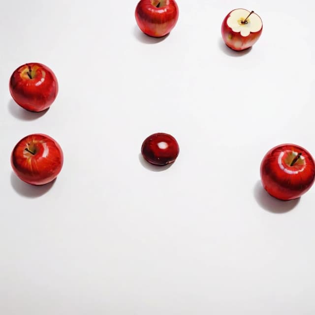 a red apple on a white table
