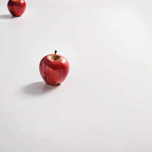 a red apple on a white table