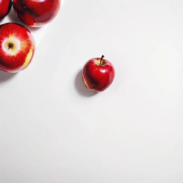 a red apple on a white table