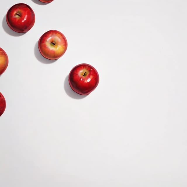 a red apple on a white table
