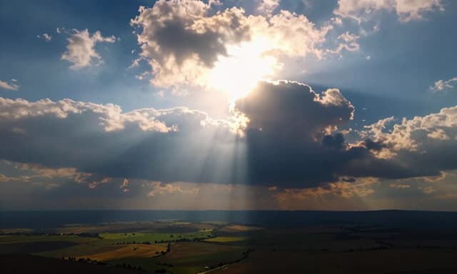 The overall composition creates a powerful contrast between the celestial and the terrestrial. The scene evokes a sense of awe, wonder, and tranquility, as if witnessing a divine moment where the heavens and earth are in perfect harmony. The lighting is dramatic, with the sun's rays creating strong highlights and casting long shadows, enhancing the three-dimensional quality of the landscape. This image is a stunning example of digital artistry, combining realistic landscape elements with fantastical, otherworldly lighting to create a truly magical and serene atmosphere.