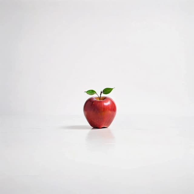 a red apple on a white table