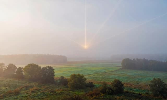 Wide panoramic landscape of ancient Rus’ in vertical 9:16 format. The scene is enveloped in a thick, opalescent fog that obscures details. As the camera slowly pans, the fog doesn’t just dissolve—it visibly streams toward a single vanishing point on the horizon, revealing a clear, vibrant landscape beneath. Thin glowing lines trace through the sky like energy currents. Atmosphere: mystical, hopeful, with a feeling of awakening. Soft lighting, muted tones turning into saturated natural colors.