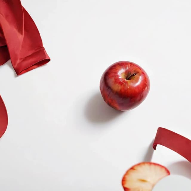 a red apple on a white table