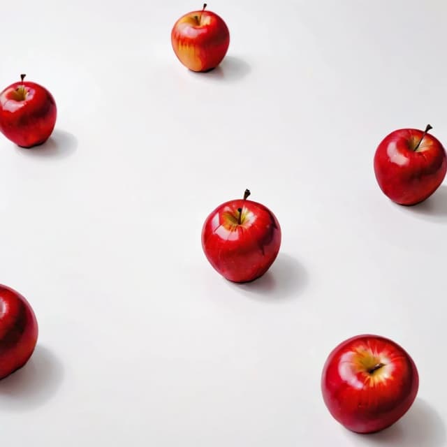 a red apple on a white table