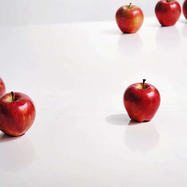 a red apple on a white table