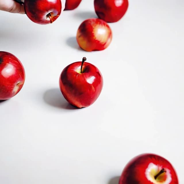 a red apple on a white table