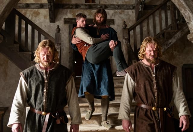 Крепкий высокий мужчина с каштановыми волосами и бородой несет на плече худого низкого мужчину, средневековая одежда, средневековая гостиница, с лестницы спускаются два крепких высоких мужчин с русыми волосами, отвращение