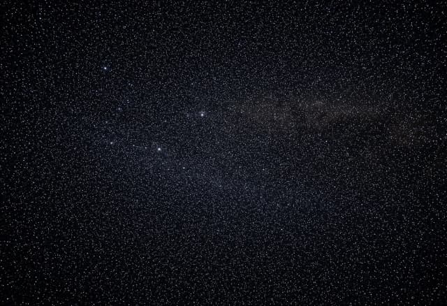 A vast, endless field of countless shimmering stars scattered across the deep black void of dark matter space. No galaxies, no spirals, no central objects — just pure, dense starfield stretching into infinity. 16:9 aspect ratio, cinematic lighting, photorealistic, 8k resolution, majestic cosmic atmosphere, subtle nebula dust wisps in the background.