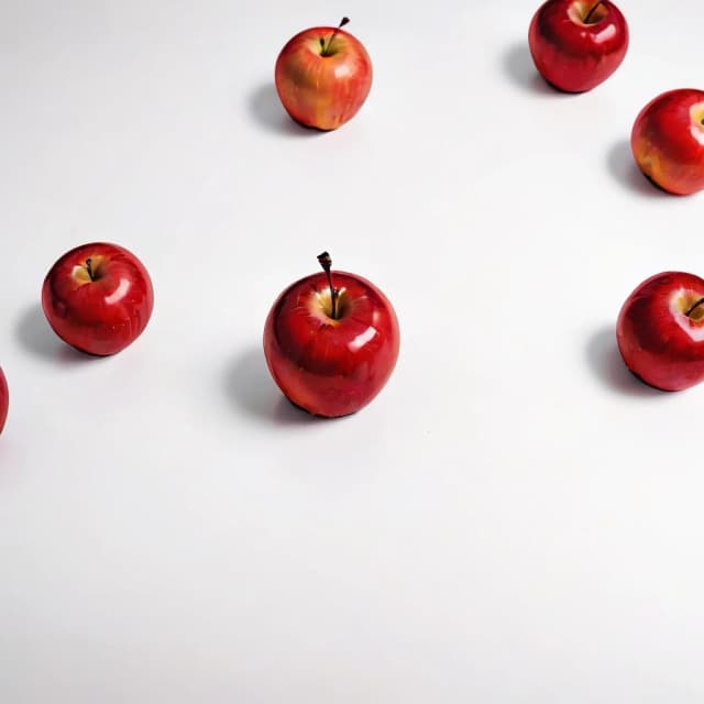 a red apple on a white table