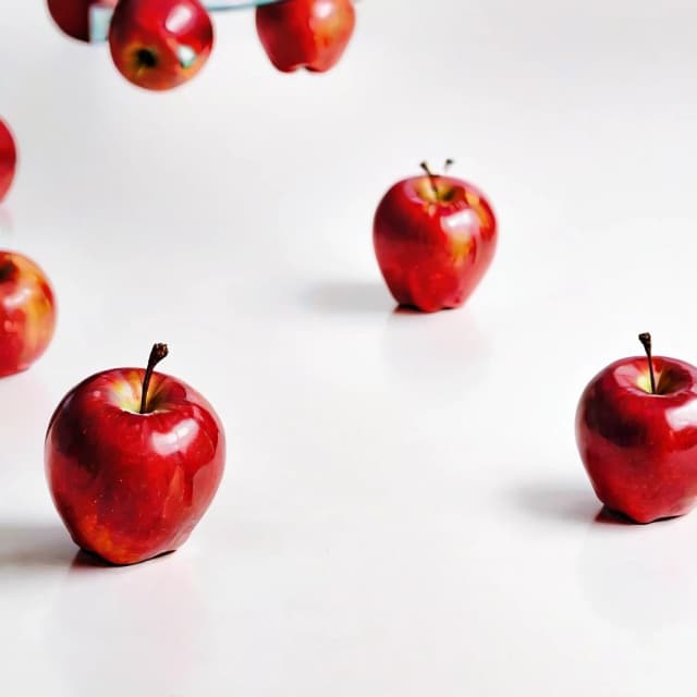 a red apple on a white table