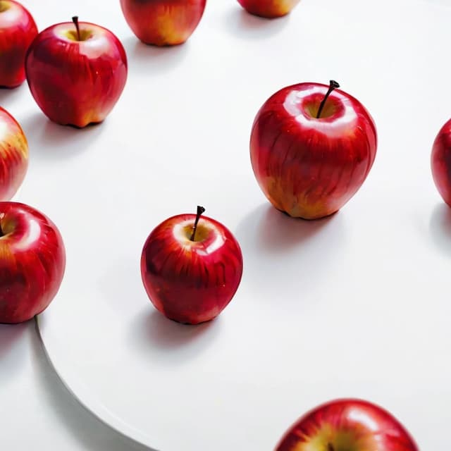 a red apple on a white table