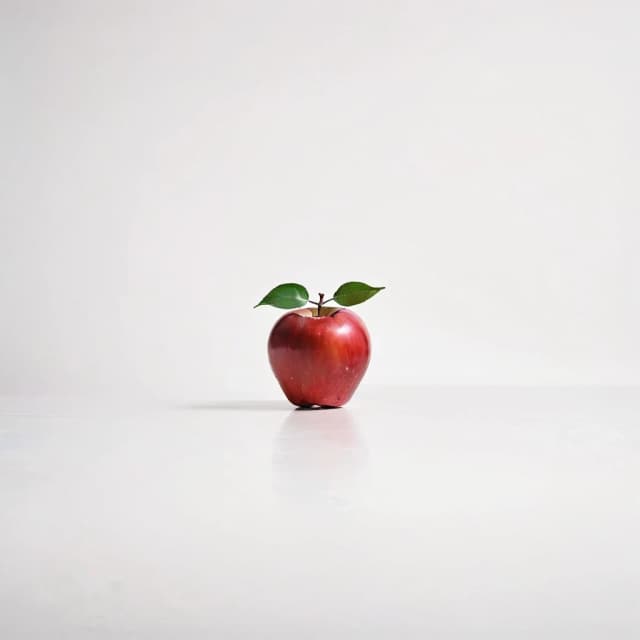 a red apple on a white table