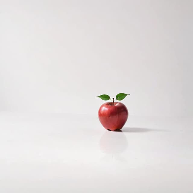 a red apple on a white table