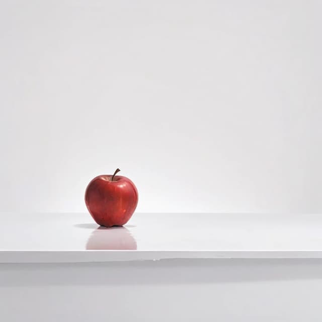 a red apple on a white table