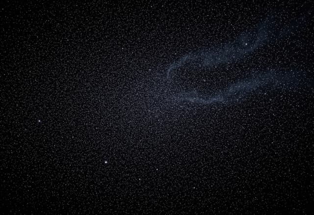 A vast, endless field of countless shimmering stars scattered across the deep black void of dark matter space. No galaxies, no spirals, no central objects — just pure, dense starfield stretching into infinity. 16:9 aspect ratio, cinematic lighting, photorealistic, 8k resolution, majestic cosmic atmosphere, subtle nebula dust wisps in the background.