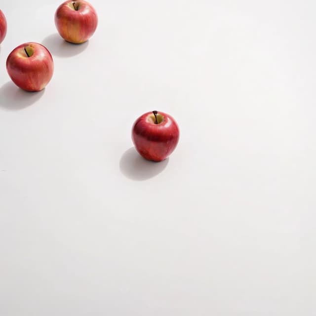 a red apple on a white table